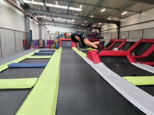 Uczeń ZSZiP pokazuje swoje najlepsze popisy akrobatyczne na trampolinie.