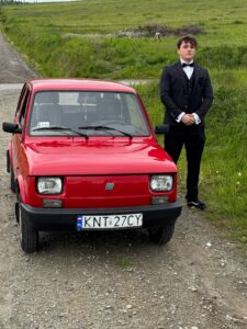 Uczeń fotografuje się przy samochodzie zdjęcie 5