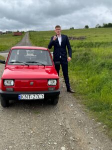 Uczeń fotografuje się przy samochodzie zdjęcie 7