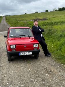 Uczeń fotografuje się przy samochodzie zdjęcie 3