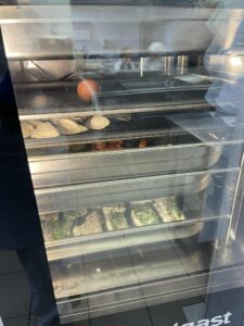 Półki w piecu konwekcyjno parowym z pierogami, mięsem i rybami