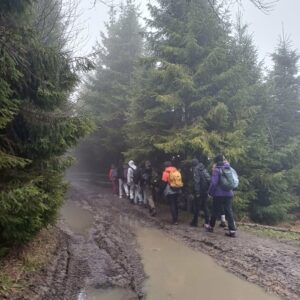 Grupa osób na błotnistej drodze