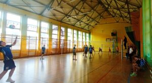 Skoncentrowani i skupieni chłopcy walczą na boisku do siatkówki o każdą piłkę.