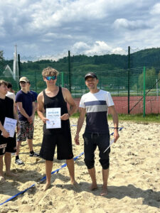 Uczeń dumny z zajęcia 1 miejsca w zawodach z piłki plażowej.